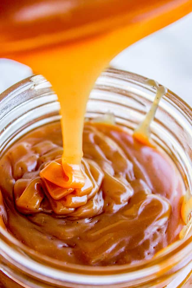 caramel sauce being poured into a mason jar.