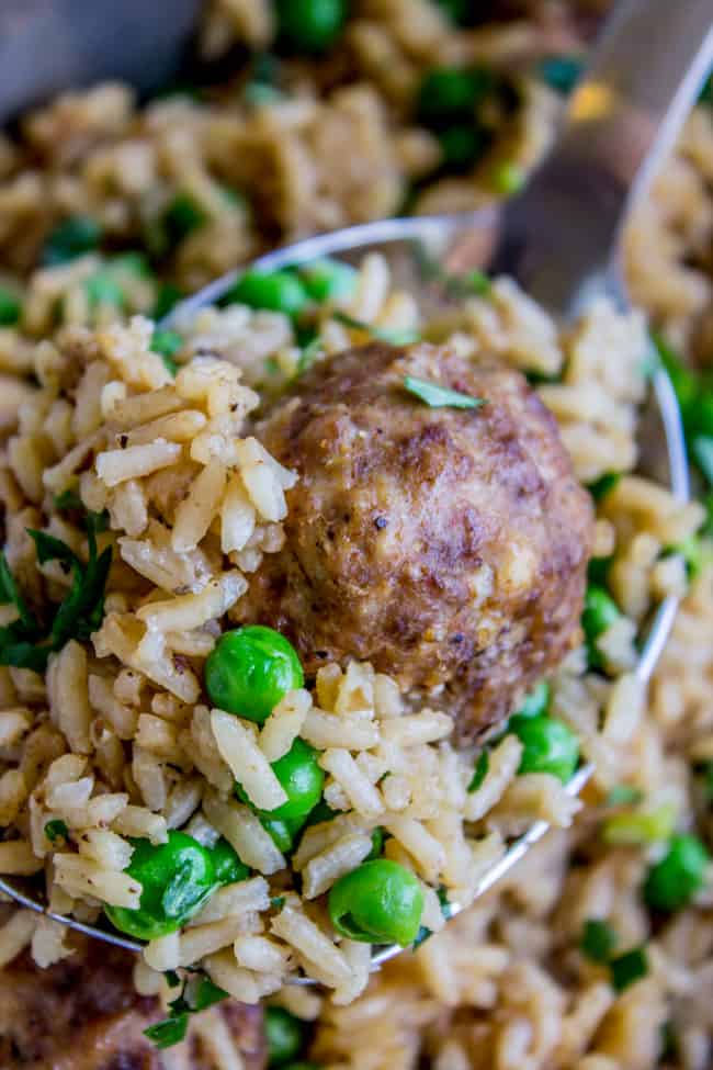 beef meatballs with rice and peas on a big metal spoon. 