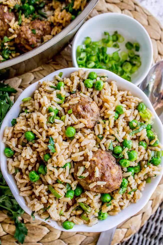 meatballs with rice and peas in a white bowl. 