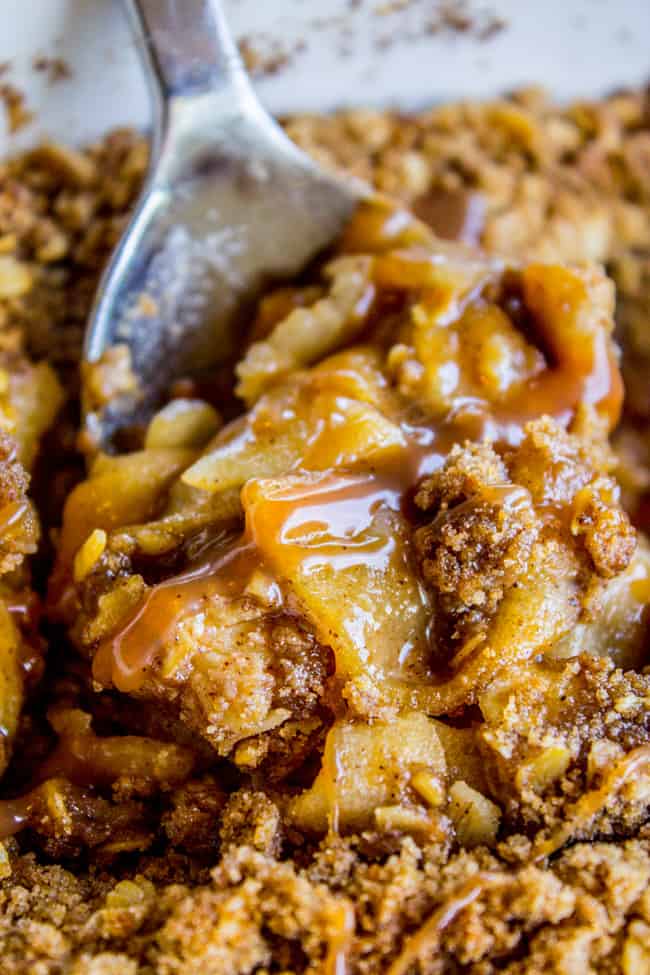 a spoon lifting a piece of apple crisp with oats.