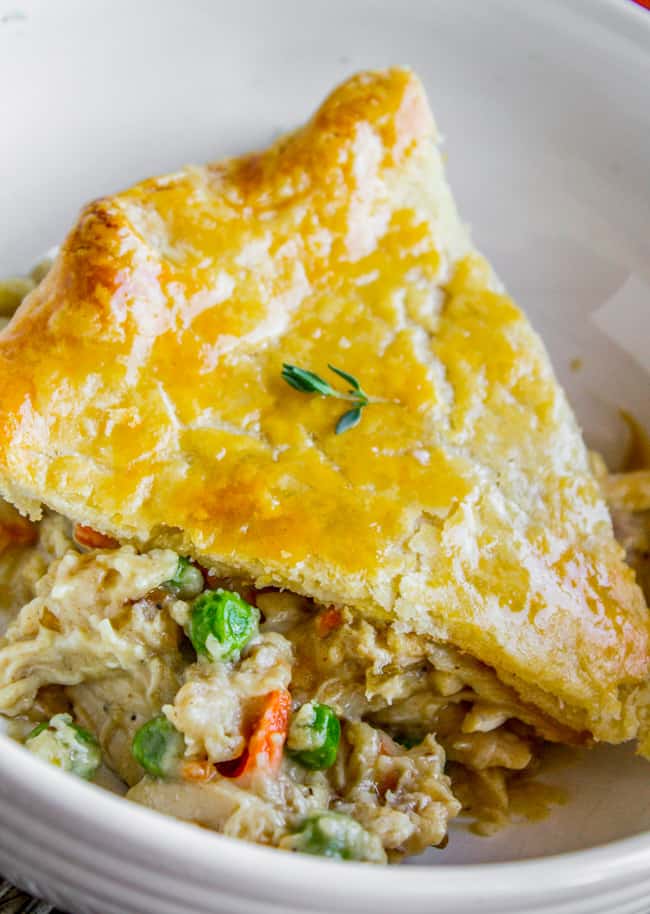 a slice of homemade chicken pot pie in a white bowl.