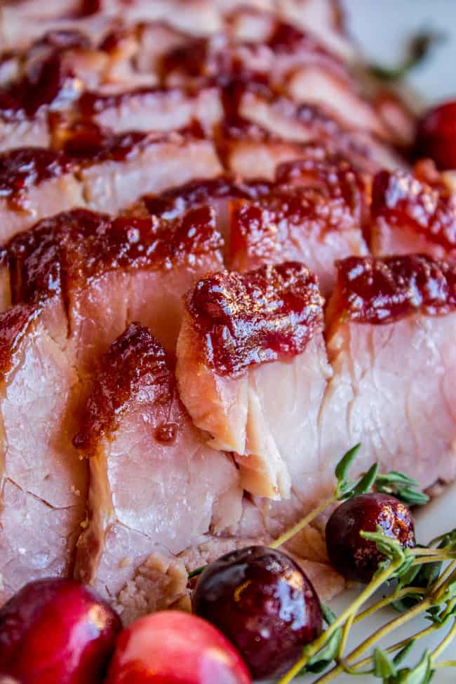 Close up sliced ham with homemade glaze and cranberries