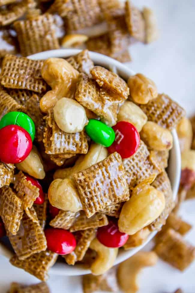 Christmas Chex Mix in a white bowl with M&M's gleaming