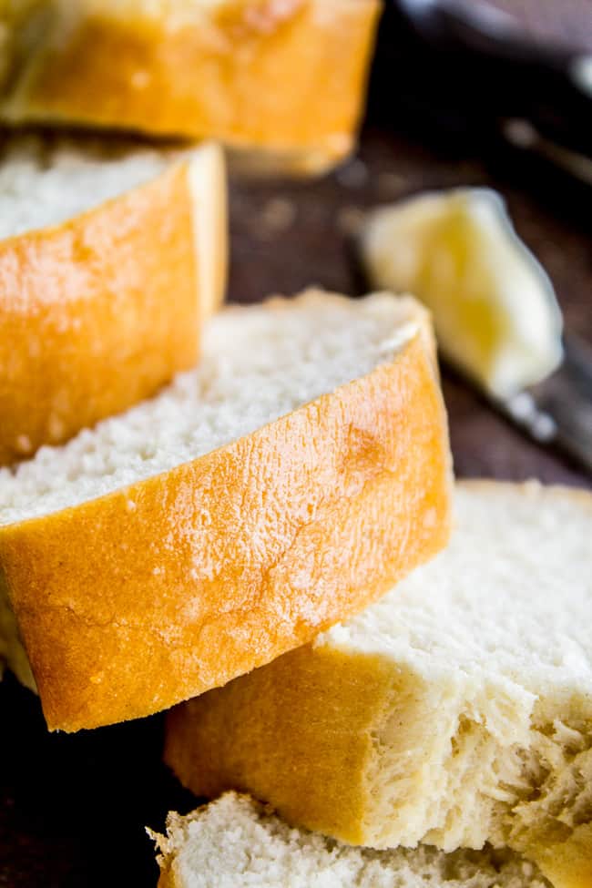 slices of homemade french bread with butter in the background. 