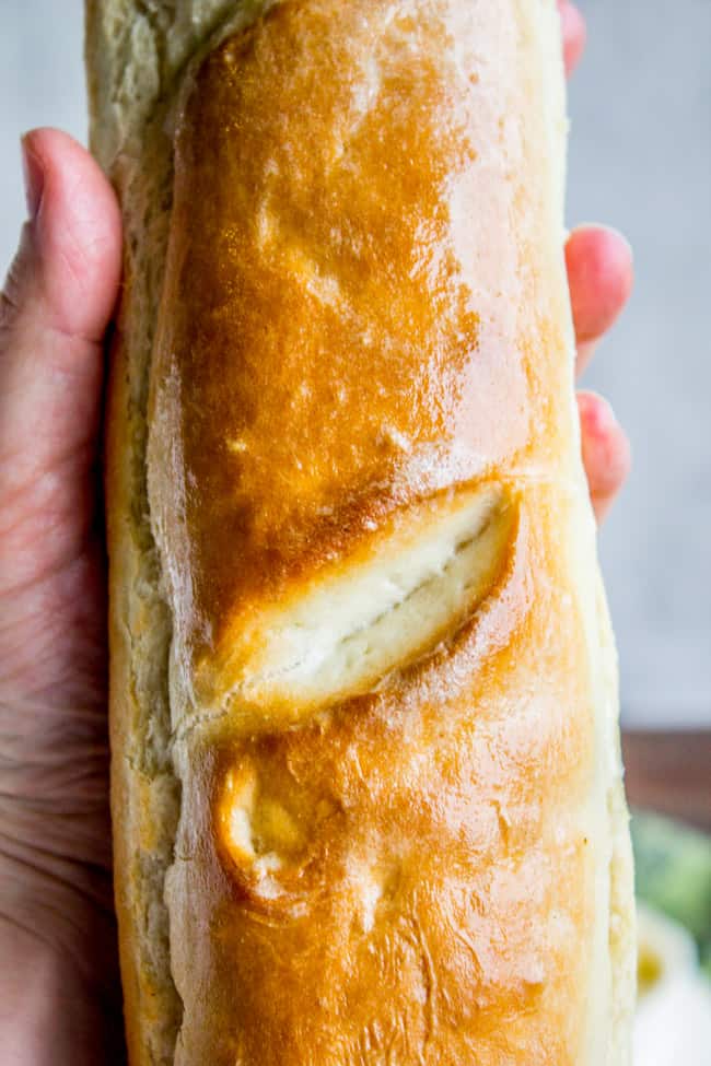 a beautifully browned load of homemade French bread in someone's hand.