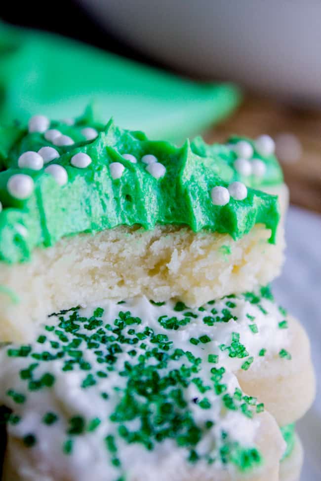 Green frosting for cookies with sprinkles on top of cookie with bite taken out of it