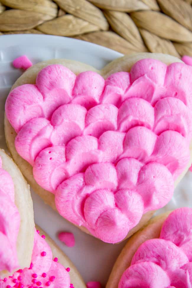 close up of best sugar cookies with dollops of pink buttercream frosting
