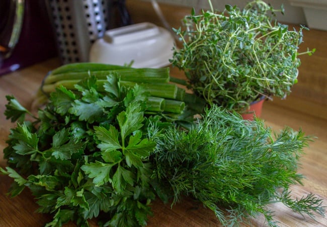 fresh herbs on a wooden cutting board.