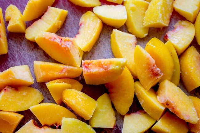 frozen peaches on a cutting board.