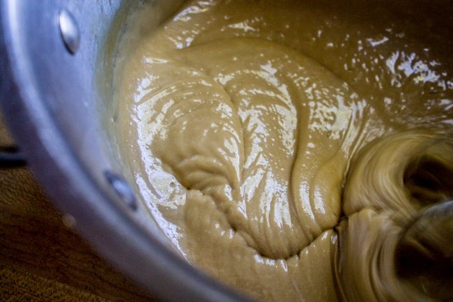 beating brown sugar frosting with a mixer.