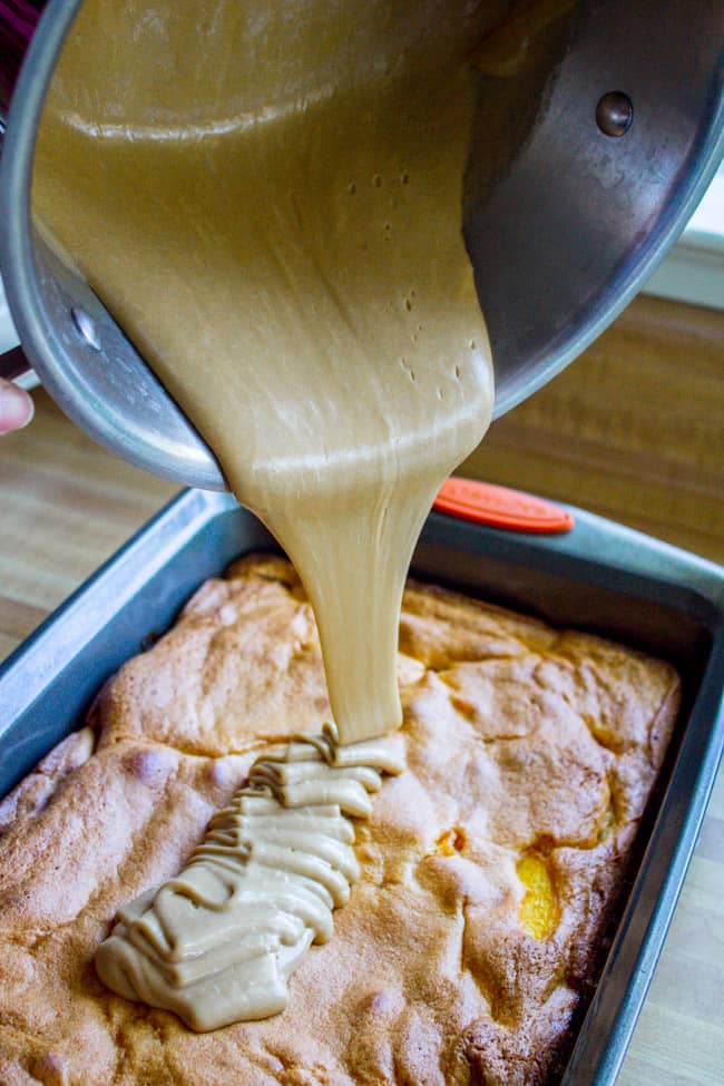 pouring brown sugar frosting onto a peach cake.