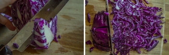 a purple cabbage being sliced on a wooden cutting board.