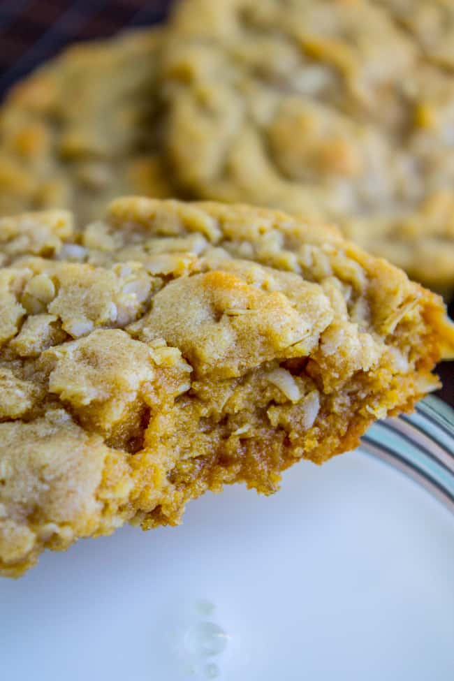 a chewy peanut butter oatmeal cookie about to be dunked in a glass of milk. 