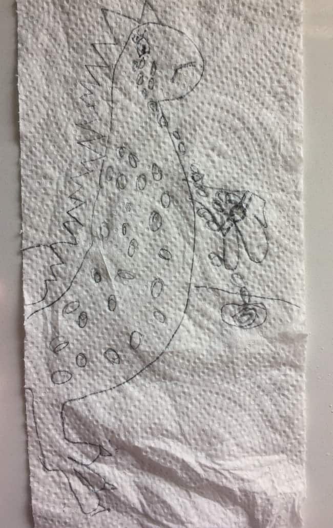 Child's drawing of a dinosaur on a paper towel.