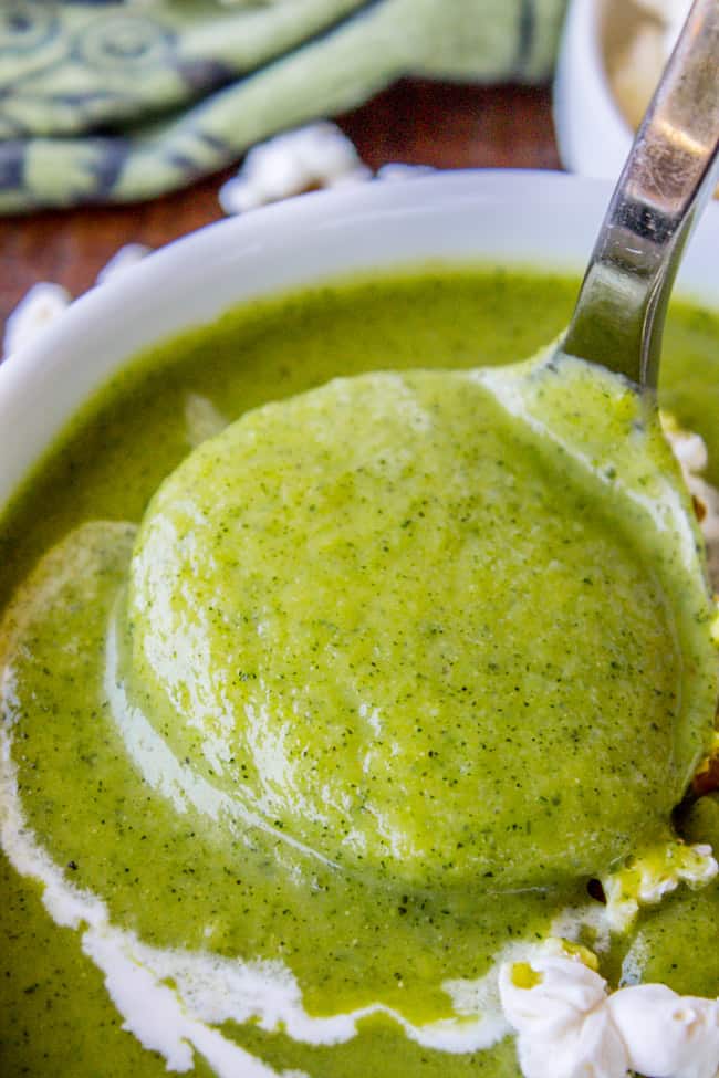 creamy zucchini soup being lifted by a spoon.