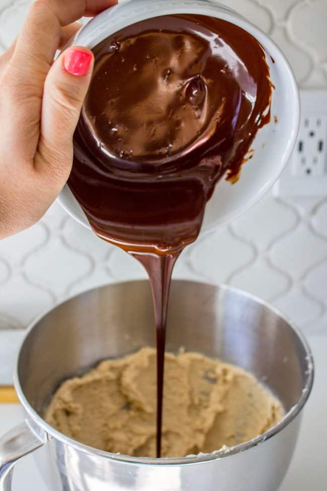 Pouring melted chocolate into cookie dough.