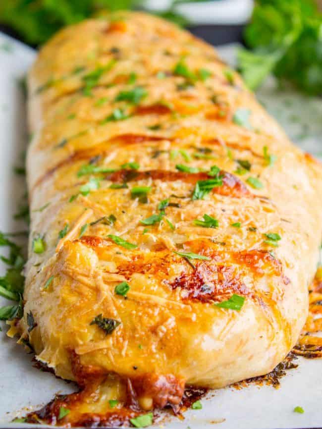 Stromboli with browned cheese and fresh parsley on top.