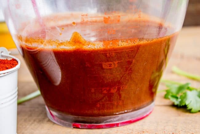 enchilada sauce in a plastic measuring cup.