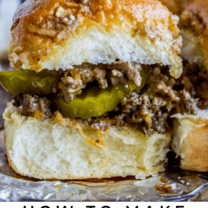 Close-up of a juicy cheeseburger slider with ground beef, melted cheese, pickles, and a soft bun, set on foil. Text below reads: Cheeseburger Sliders - The Food Charlatan.