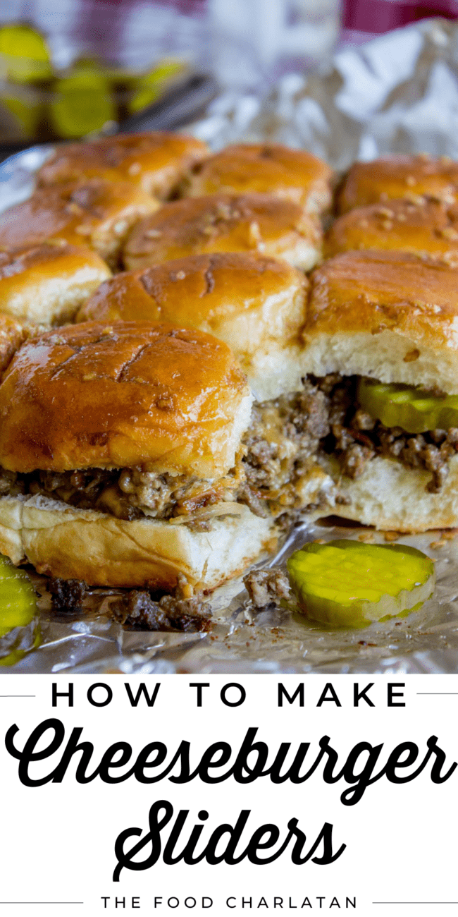 cheeseburger sliders on tinfoil with sliced pickles.