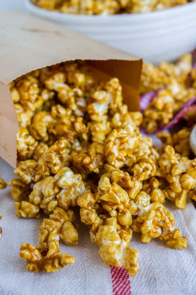 homemade caramel popcorn spilling from a paper bag.