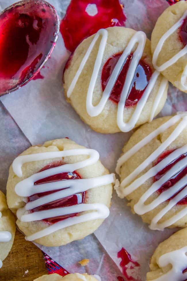 raspberry jam thumbprint cookies with glaze drizzled on top. 