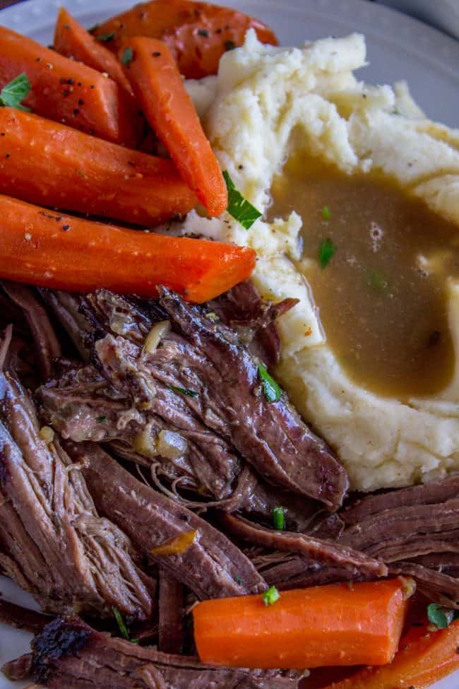 Easy Fall-Apart Pot Roast with Carrots (Slow Cooker) from The Food Charlatan. Super tender, juicy, fall-apart crock pot roast is not as hard as you think! This slow cooker recipe uses a few simple ingredients (one of them is patience) to make the most flavorful pot roast ever! #potroast #slowcooker #crockpot #roast #chuckroast #tender #juicy Roast meat and carrots with mashed potatoes and gravy