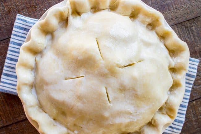 savory pie with vented pie crust on a blue and white dish towel. 