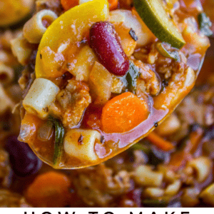 A close-up of a ladle lifting chunky slow cooker minestrone soup, packed with vegetables, beans, and pasta. The Food Charlatan logo is displayed below. Warm comfort comes to life in every scoop of this classic dish.