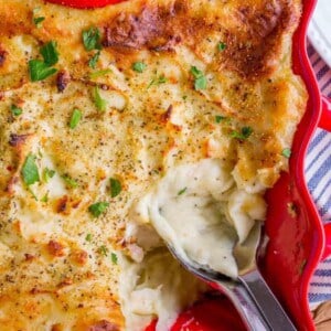 make ahead mashed potatoes in a red serving dish with spoon.