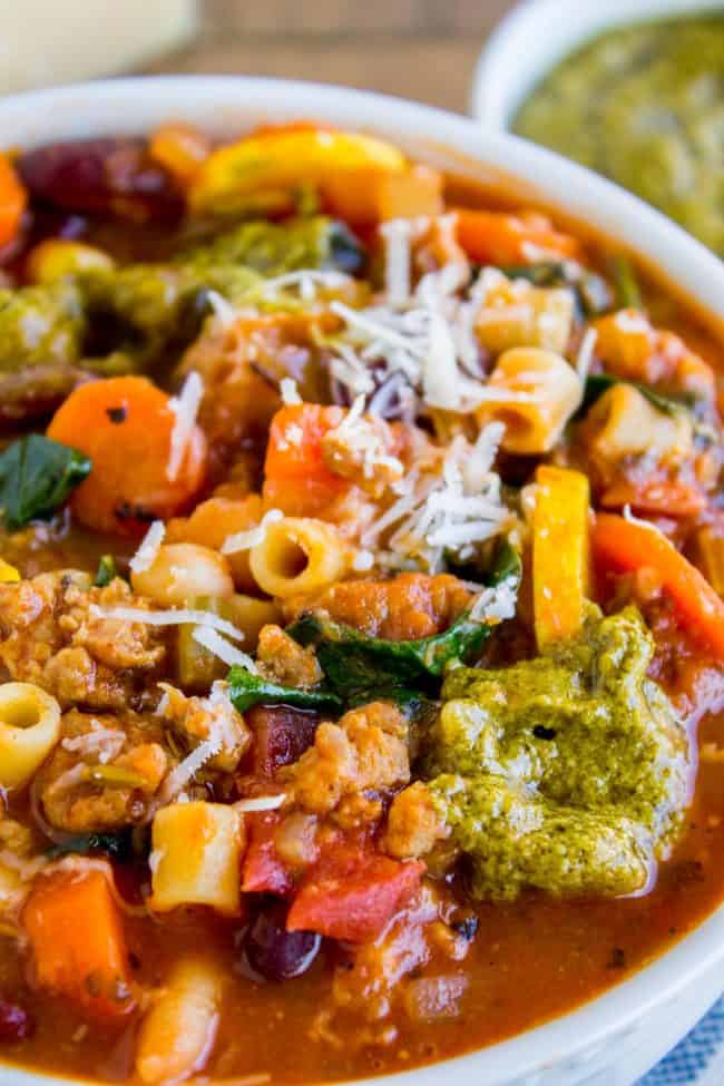 minestrone soup with pesto and sausage in a bowl.
