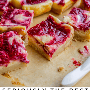 raspberry cheesecake bars on parchment paper.