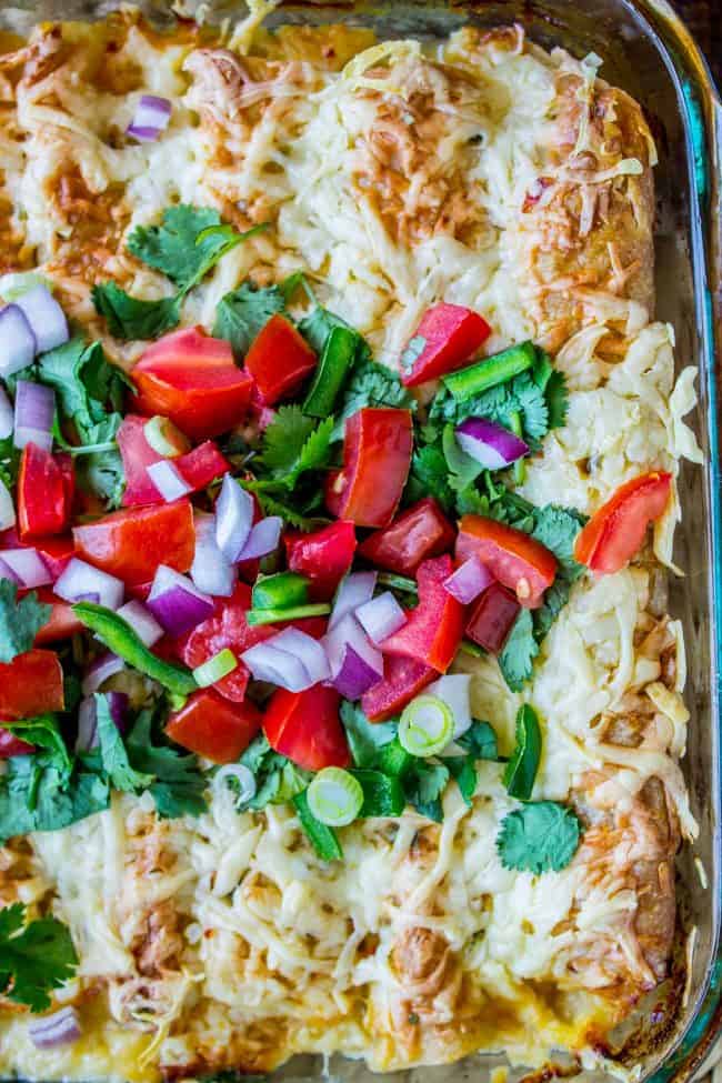 pan of creamy white chicken enchiladas with tomatoes