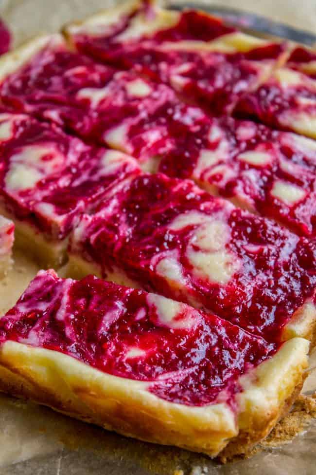 cutting homemade raspberry cheesecake bars. 