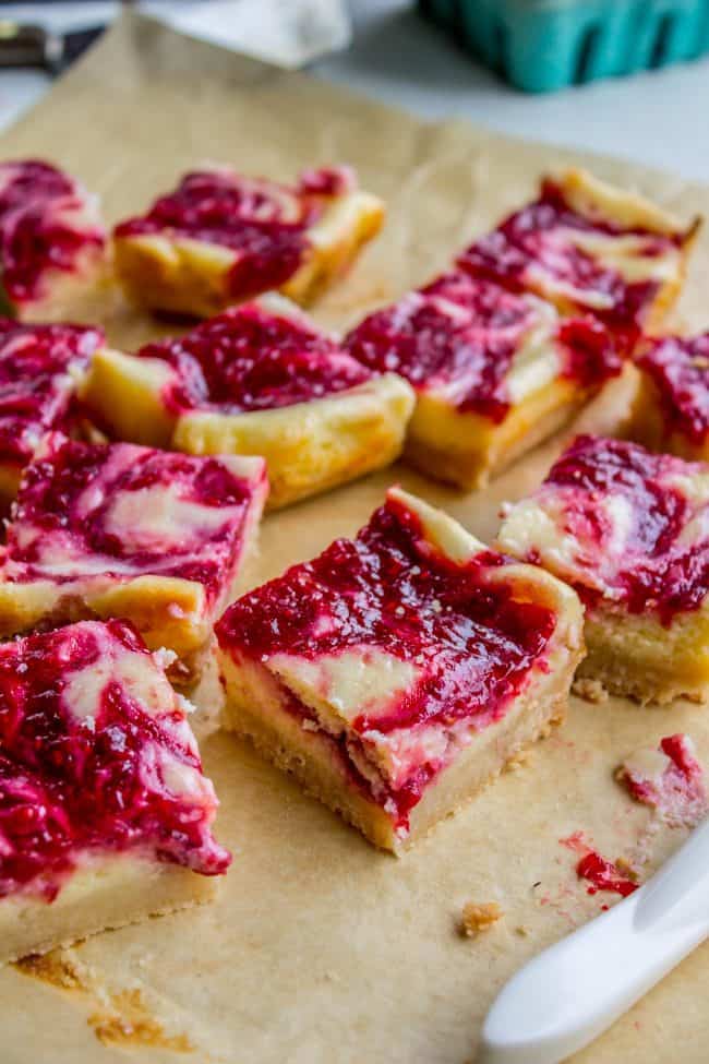 homemade raspberry cheesecake bars on parchment paper.