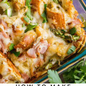 A close-up of a baked savory bread pudding with chunks of bread, ham, asparagus, melted cheese, and fresh herbs in a casserole dish. Text overlay reads: Savory Bread Pudding with Ham & Asparagus.