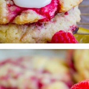 Close-up of Raspberry Lemon Cookies topped with white icing and fresh raspberries, featuring swirls of raspberry in the cookies. Slices of lemon are placed nearby, highlighting the fresh ingredients.