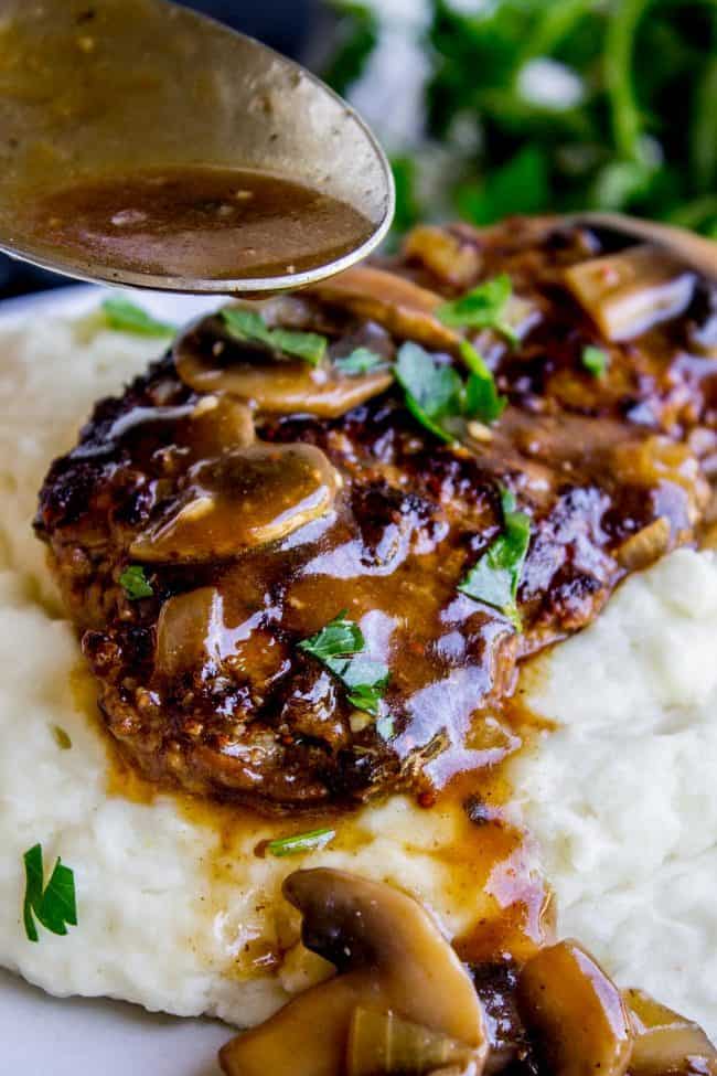 salisbury steak with mushroom gravy on top of creamy mashed potatoes.