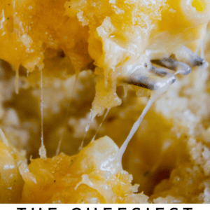 Close-up of creamy, golden macaroni and cheese with melted, stretchy cheese strands. This rich and gooey comfort food highlights cheesy texture. Text below reads: The cheesiest Macaroni and Cheese, The Food Charlatan.