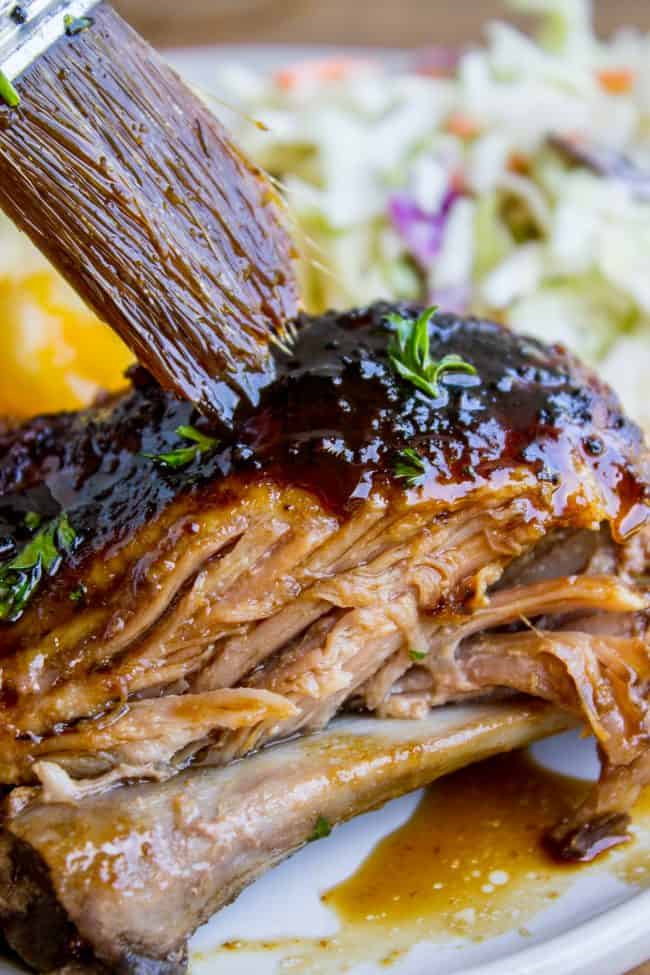 slow cooker pork ribs being brushed with honey balsamic glaze