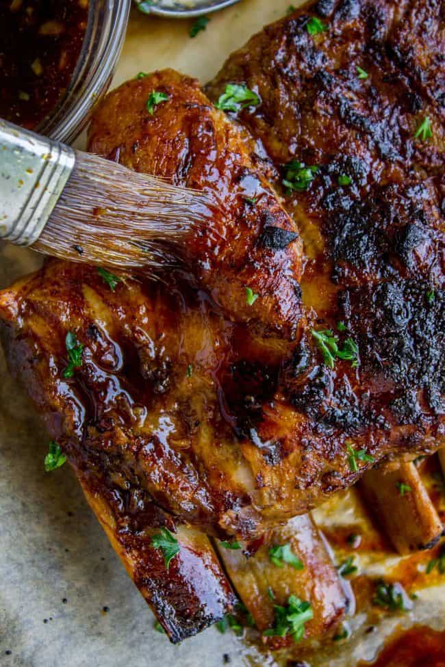 slow cooker ribs being brushed with glaze