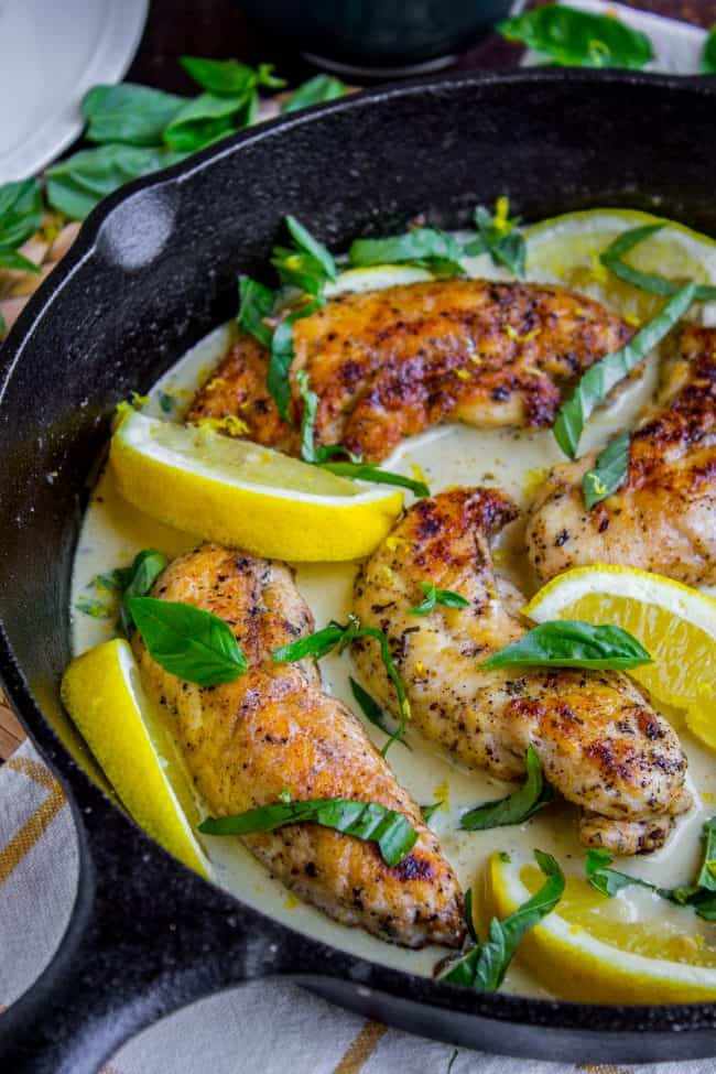 lemon basil cream sauce surrounding chicken tenderloins in a cast iron skillet.