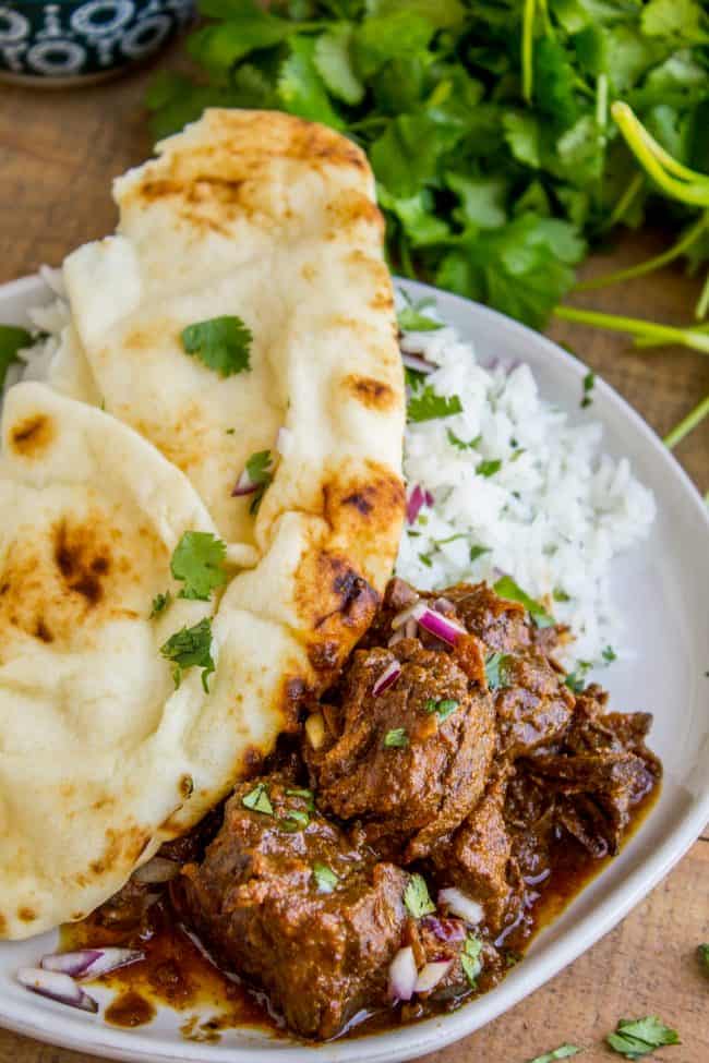 beef curry with cilantro, naan, and rice.