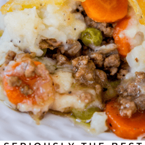 Close-up of a classic shepherd’s pie with a golden cheesy crust over layers of mashed potatoes, ground meat, peas, and carrots. Text below reads: “Seriously the Ultimate Classic Shepherds Pie.”.
