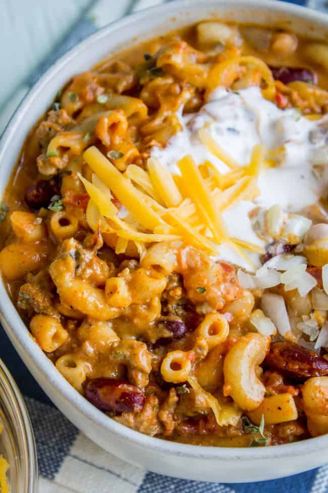 chili mac and cheese topped with sour cream and shredded cheddar.
