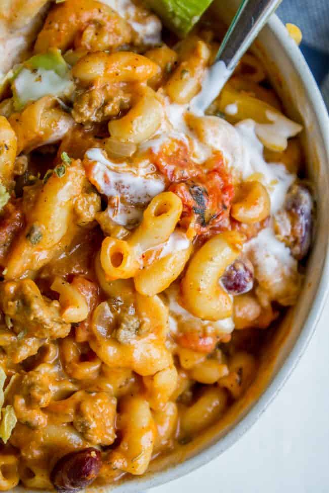 chili mac with sour cream in a bowl with a spoon. 