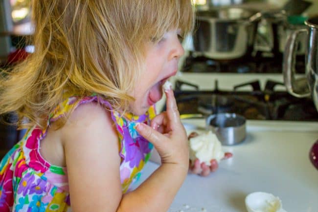 little girl eating butter supposed to have been used in caramel cake recipe