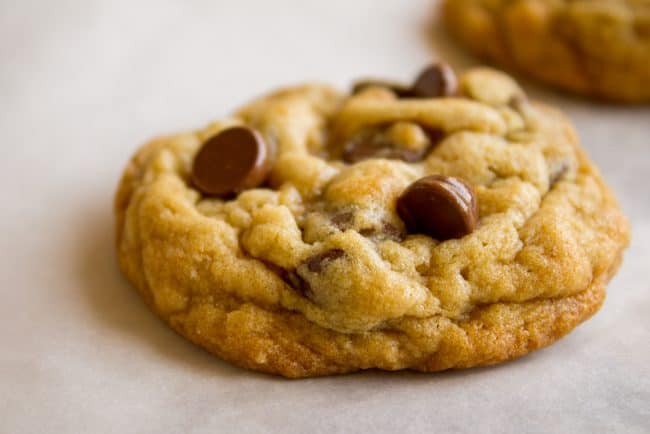 a single chocolate chip cookie on parchment paper.