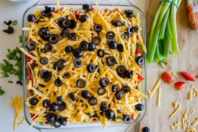 shredded cheese and black olives on top of dip.