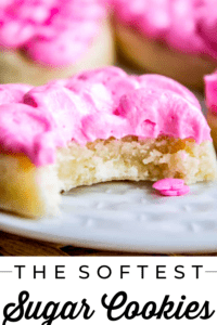 Soft Sugar cookie with pink frosting and a bite taken out of it on a white plate